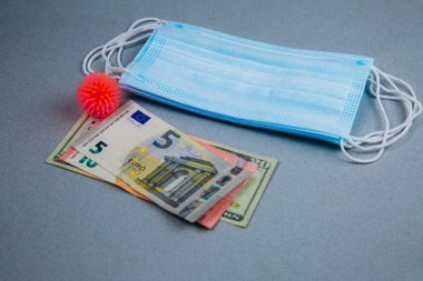 Tıbbi maske, soyut virüs modeli ve gri arka planda para, dünya koronavirüs salgını ve ekonomik hasar. Corona virüsü konsepti.