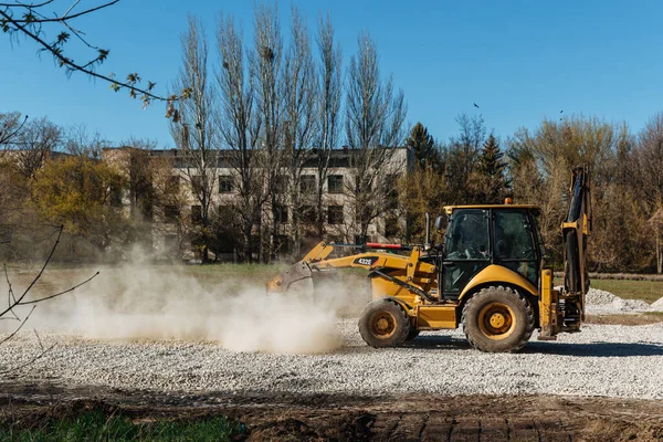 Dneprorudnoe / Ukrayna - Nisan 08 2020: Bir traktör kovadan çakıl döktü