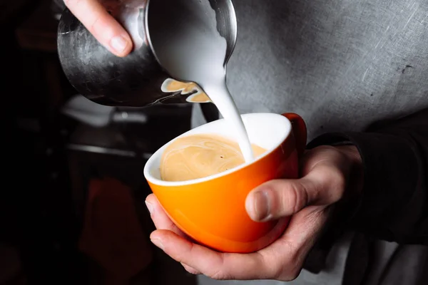巴里斯塔的手把热牛奶倒在咖啡杯里做拿铁艺术 靠近点 — 图库照片