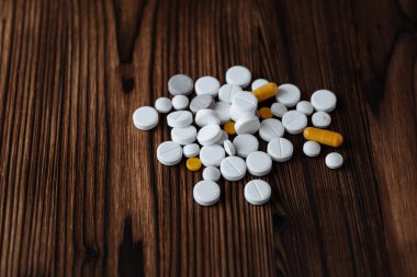 Ahşap arka planda çeşitli ilaç kapsülleri ve tabletler. Fotokopi alanı ile sağlık hizmeti kavramı