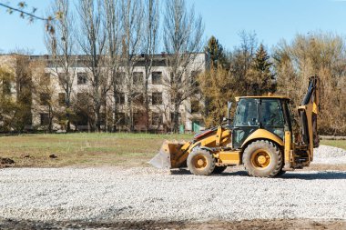 Dneprorudnoe / Ukrayna - Nisan 08 2020: Bir traktör kovadan çakıl döktü