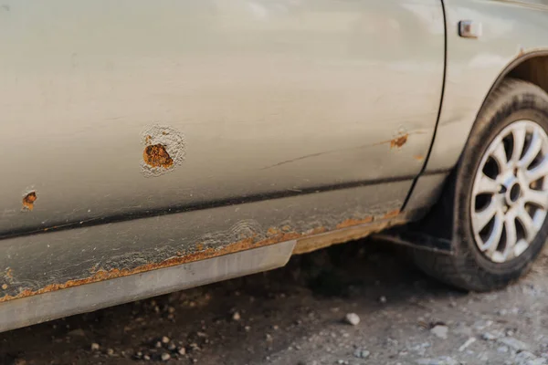 Paslı ve metal aşınmalı bir araba kapısı. Tamire ve yol tuzuna ihtiyacım var..
