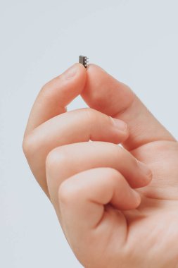 Küçük siyah bir çip bir çocuğun elini tutuyor. Salgın bir koronavirüsten sonra insanların yontulması. Kapat.