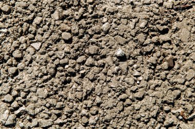Gri, ezilmiş taşların arka planı çamurda farklı şekillerde..