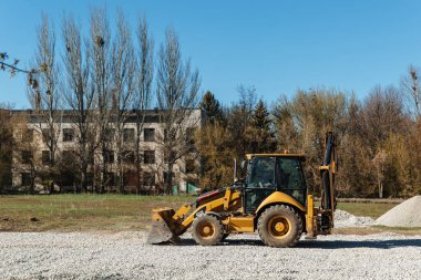 Dneprorudnoe / Ukrayna - Nisan 08 2020: Bir traktör kovadan çakıl döktü