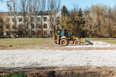 Dneprorudnoe / Ukrayna - Nisan 08 2020: Bir traktör kovadan çakıl döktü