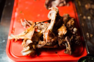 Yemekten sonra kemiklerin kalıntıları kırmızı tepside..