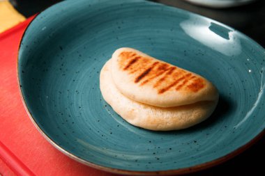 Yuvarlak, mavi bir tabakta pirinç çöreği yatıyor..