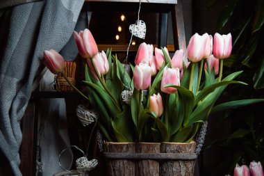 Tahta bir kutuda bir buket yumuşak pembe lale. Evin dekorasyonu. Neşeli arkaplan.