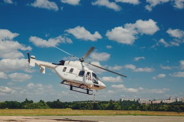 Beyaz bir helikopter pistten kalkıyor..