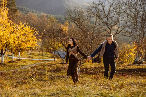 Jong stel houdt hand in hand wandelen in het park op een herfstdag — Stockfoto