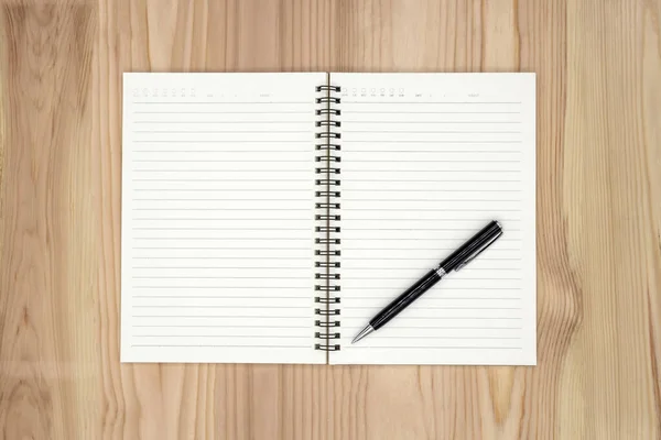 Blank notebook with a pen on a wooden table — Stock Photo, Image