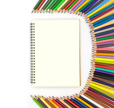 Çeşitli renklerde kalemlerle çevrili boş bir kitap