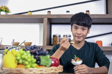 Yakışıklı genç erkekler meyveli yoğurt yemekten mutlu olurlar..