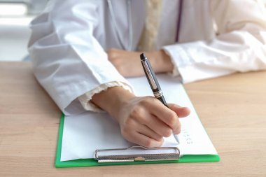 Notun üzerinde oturan bir kadın doktorun yakın çekimi.