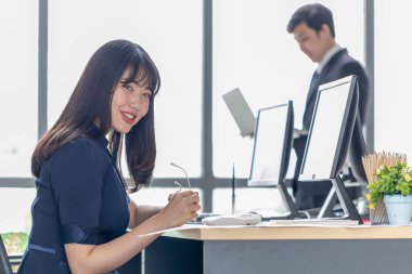 Ofis masasında gülümseyen güzel bir genç bayan.