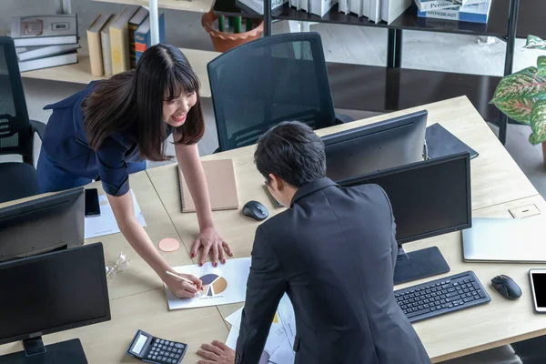 Un hombre le está explicando el trabajo a una chica en el escritorio . — Foto de Stock