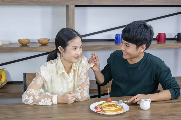 Männer füttern Frauen mit Erdbeerkuchen. — Stockfoto