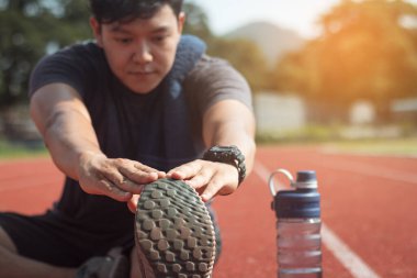 Koşucu bacaklarını açıyor. Koşu antrenmanına hazırlanıyor..