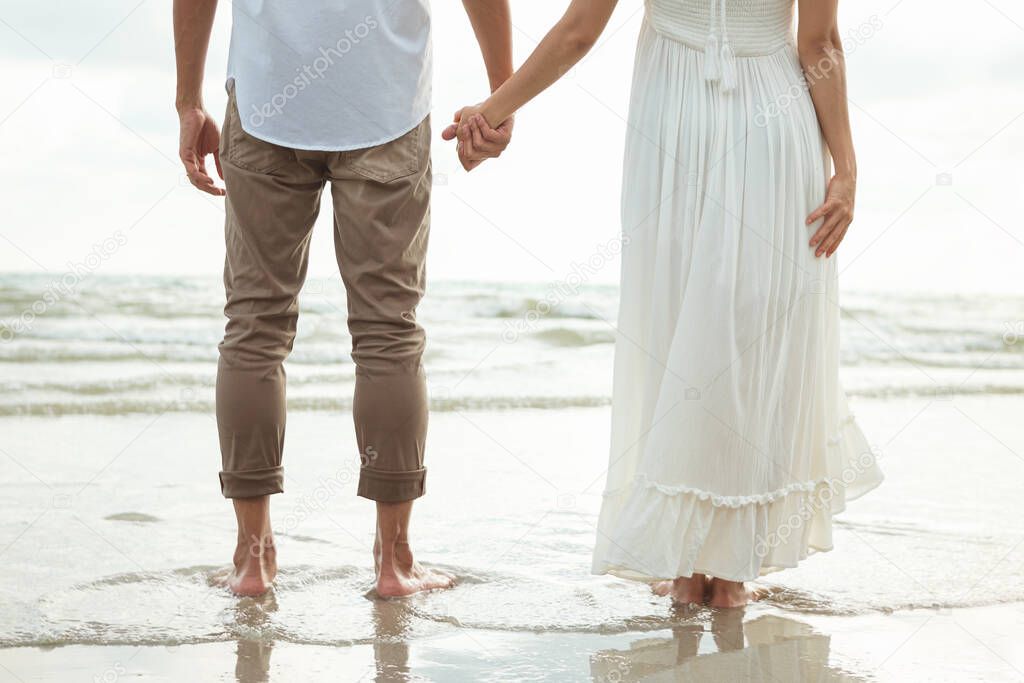 Couple hold hands on beach. Romantic couple on the beach