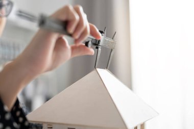 Mühendis elini mimari modeli ölçmek için Vernier Caliper 'ı kullanarak kapat. ev kavramında çalışma.