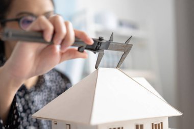 Mimari modeli ölçmek için Vernier Caliper kullanan mühendis.