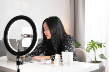 Kadın blogcu dizüstü bilgisayar kullanıyor ve aboneleriyle yorum okuyor