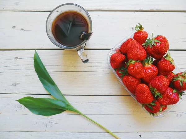 kırmızı çilek, yeşil yaprak ve beyaz arka plan üzerinde kahve fincanı