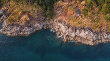 Hava görüntüsü. Turkuaz deniz suyunun üst görüntüsü kayalık sahili yıkıyor. Peyzaj arka planı. Tayland