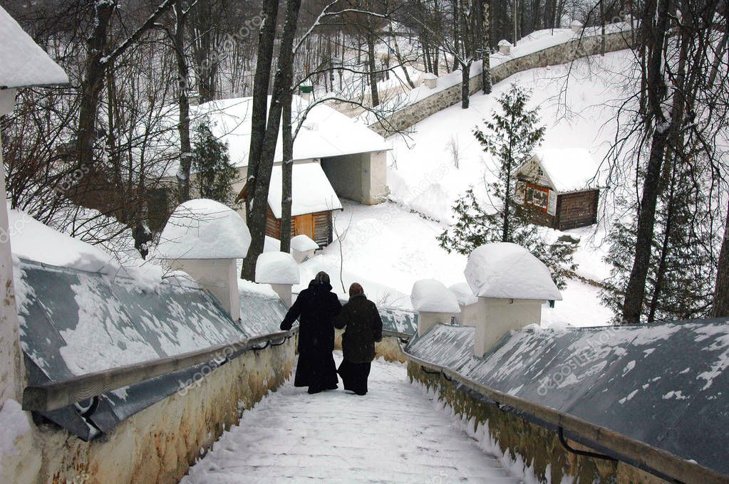 Two nuns descending the winter stairs from the old Church, Pushkin mountains, Russia