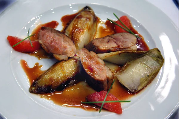 Pieces of duck breast with vegetables and French red wine sauce with garlic