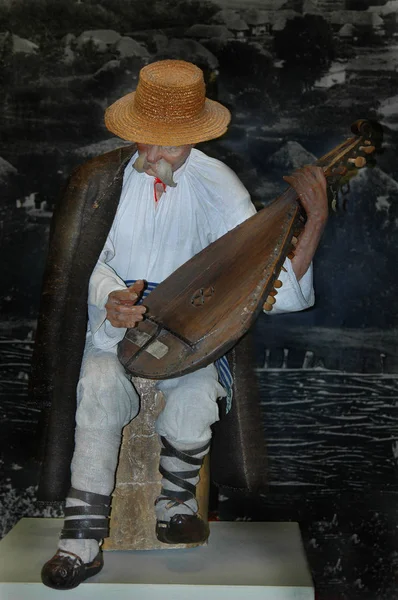 Ahşap bir oyuncak bebek (hasır şapkalı yaşlı bir adam) yaşlı bir adamın kostümünde