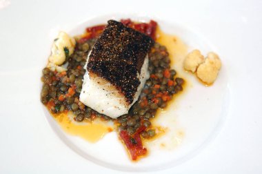 Mercimek ve baharatlı soslu beyaz balık filetosu.