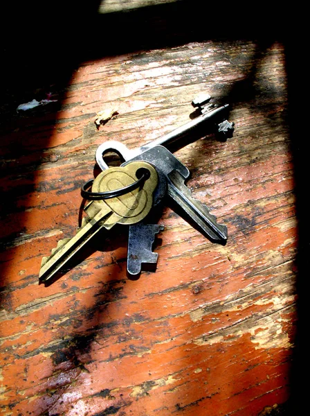 Eski evin anahtarları yıpranmış ahşap bir tezgahta.