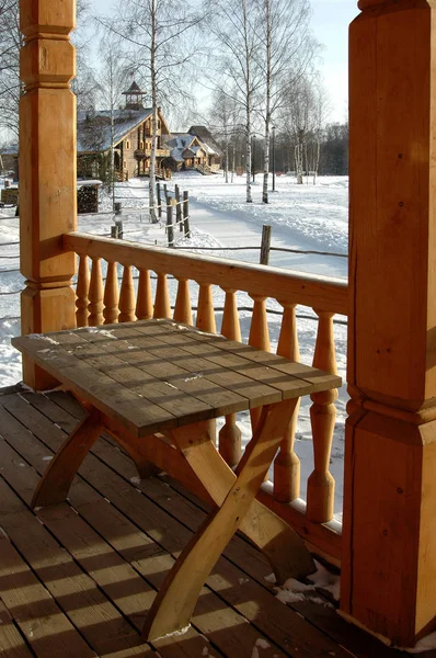 Evin ahşap bir uzantısında bir masa var.