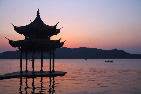 Puesta de sol con una pagoda en el hermoso lago Hangzhou —  Fotos de Stock