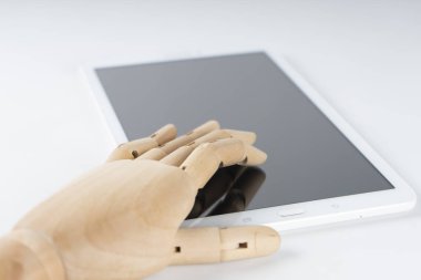 Tahta el beyaz bir tablete dokunuyor.