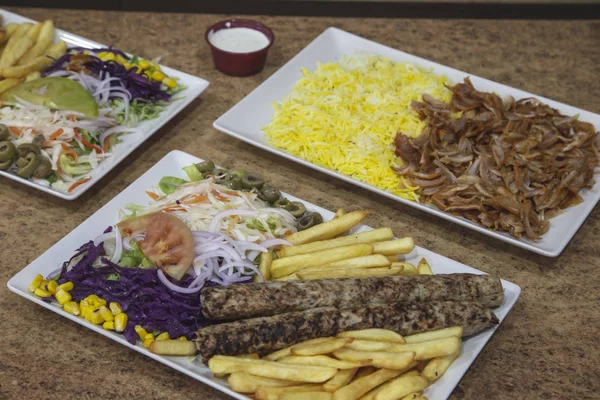 Variety of Middle Eastern dishes. Meat with rice, Seekh kebab duck with potatoes and salad.