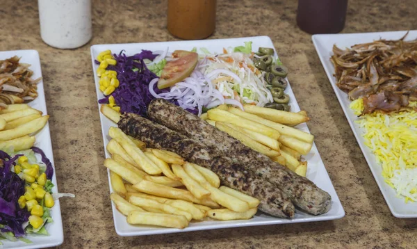 Seekh kebab plate with salad and potatoes.