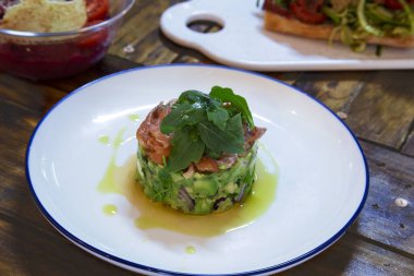 Guacamole ve füme somon salatası beyaz tabakta.