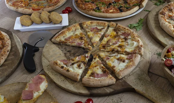 Ahşap arka planda çeşitli lezzetli pizzalar. Boşluğu kopyala.