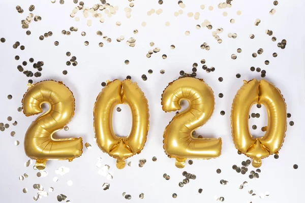 Altın konfetiyle 2020 numaralı alüminyum balonlar. Yeni yıl kutlaması. Altın Küre. Noel partisi dekorasyonu.