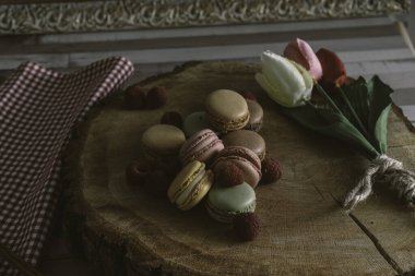 Ahşap kurabiye üzerine ahududu aromalı makarnalar.