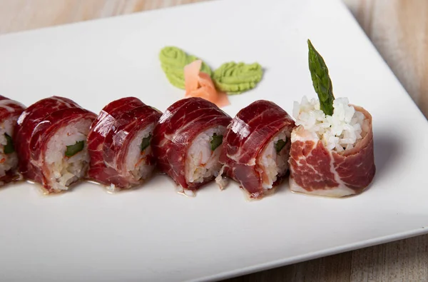 Japon Uramaki palamut ve kuşkonmaz tabağı. İzole edilmiş resim.