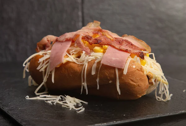 Siyah arka planda peynirli, pastırmalı ve tatlı jambonlu Venezuela sosislisi. İzole edilmiş resim