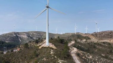 Rüzgar türbinleri dağın tepesinde dönüyor, sürdürülebilir gelecek için yenilenebilir enerji üretiyor