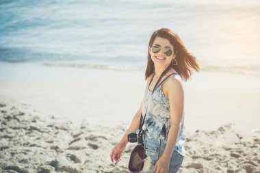 Güzel Asyalı kadın seyyah yürüyüş ve sahilde gülümsüyor