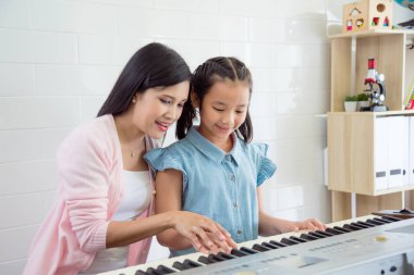 Asyalı güzel öğretmen öğrenci okulda klavye oyun öğretme