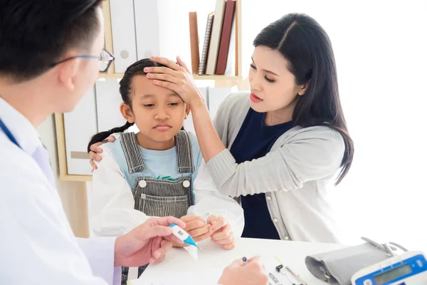 Asian Mother Touching Her Daughter Forehead While Talking Doctor — Stock Photo, Image