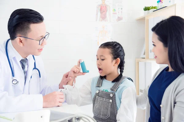亚洲男性医生向女孩解释哮喘吸入器的方法 — 图库照片